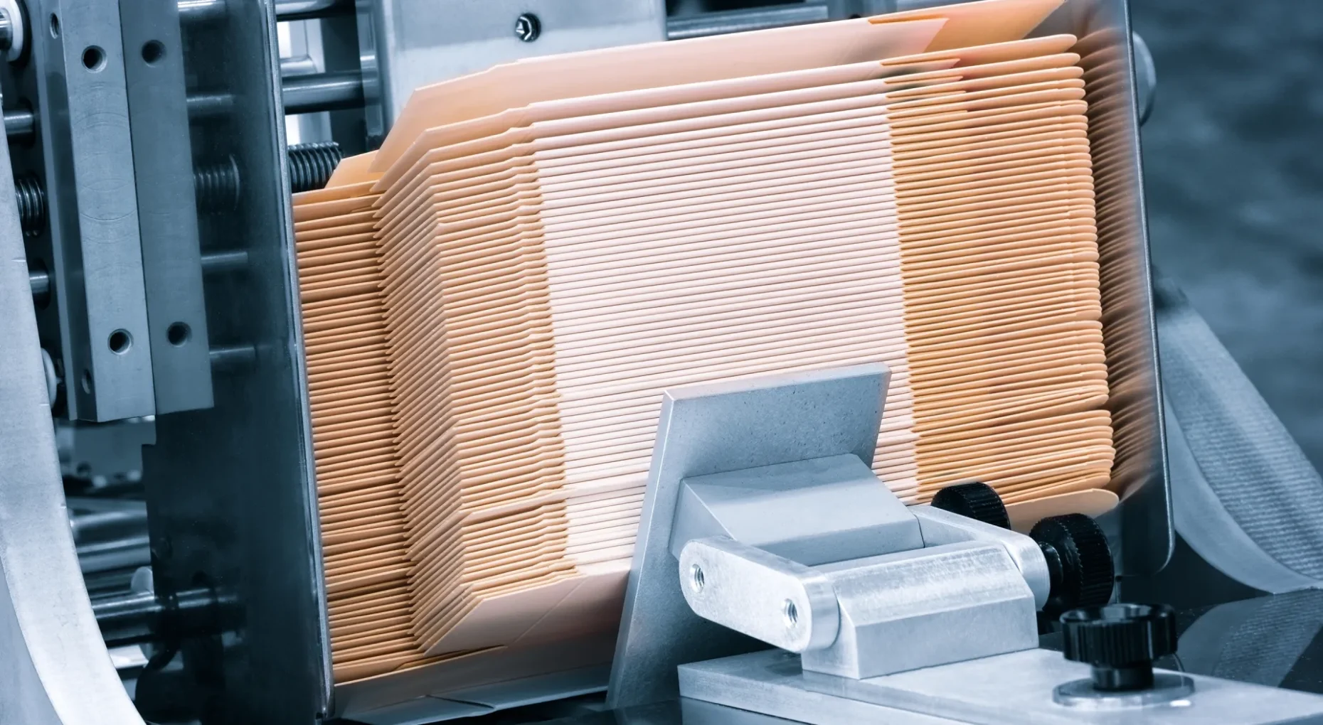 Wizualizacja maszyny do sortowania papieru, na której widać uporządkowane stosy beżowych teczek z dokumentami.