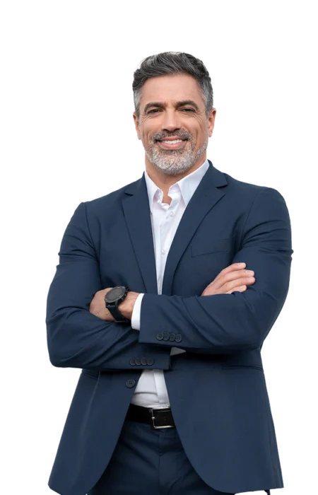 Mężczyzna w eleganckim garniturze z uśmiechem, stojący z założonymi rękami na piersi.